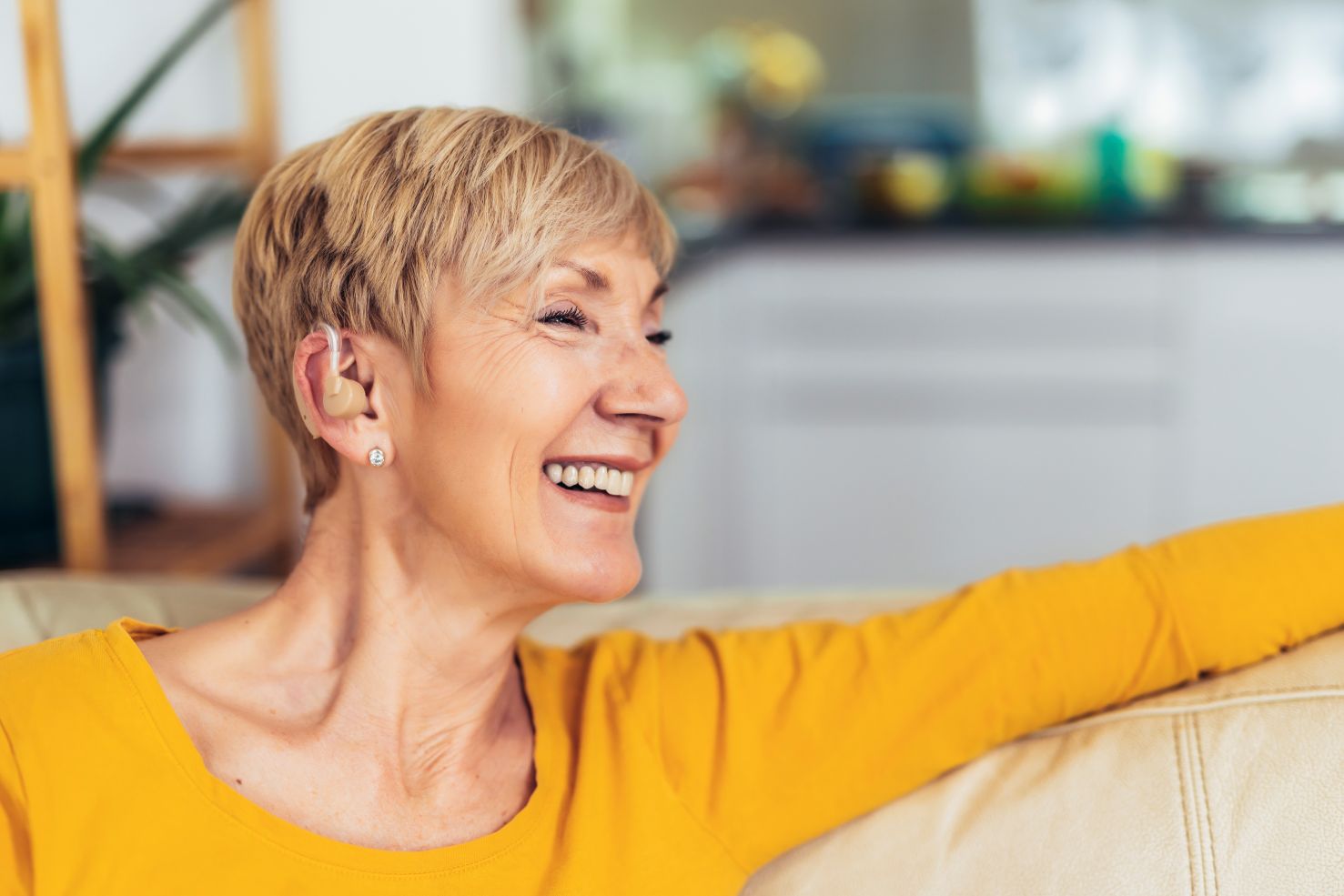 woman smiling after repairing hearing aids